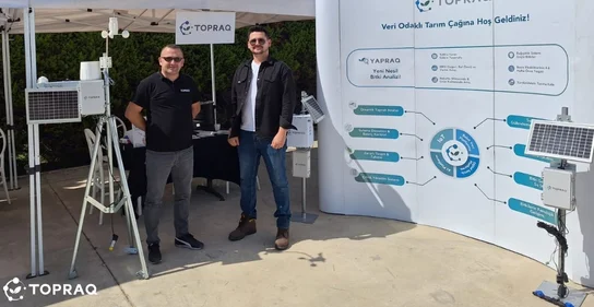 Topraq booth with two men showcasing agricultural sensors and equipment.
